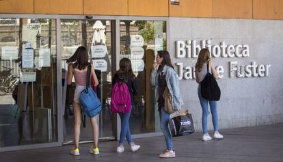 Joves usuaris, dilluns, davant les portes tancades de la biblioteca Jaume Fuster de Barcelona.