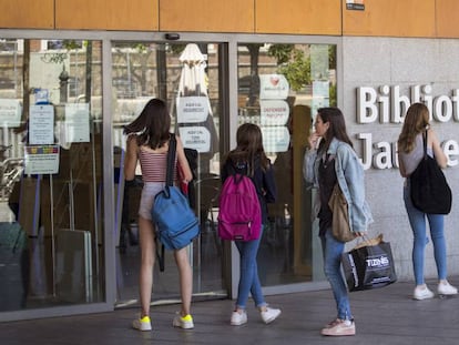 Joves usuaris, dilluns, davant les portes tancades de la biblioteca Jaume Fuster de Barcelona.