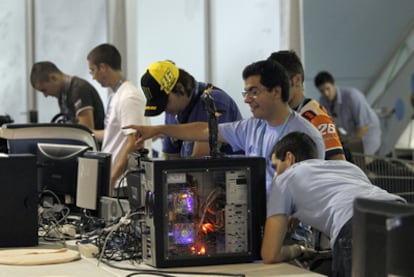 Varios asistentes a la Campus Party preparan sus ordenadores para la semana que dura el evento.