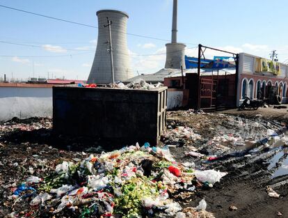 Una central térmica construida en pleno centro urbano de Hailaer, rodeada de basura.