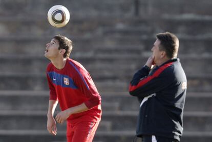 Zigic da toques de cabeza al balón  en presencia de Antic.