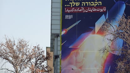 Una valla publicitaria que muestra misiles iraníes con un mensaje en persa y hebreo que dice: "preparad vuestros ataúdes", cuelga de un edificio en la plaza Palestina de Teherán, el lunes 16 de enero.