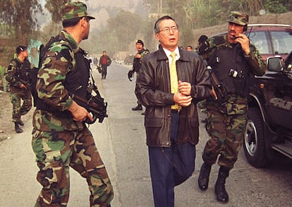 En octubre del 2000, Alberto Fujimori camina junto a policías para capturar al exjefe espía Vladimiro Montesinos, en Lima.