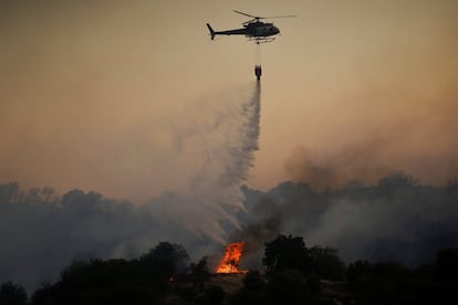 Los vecinos, que fueron desalojados de sus viviendas, han regresado a sus casas durante la noche, después de que haya quedado asegurado el perímetro de la zona, ha informado el Ayuntamiento en una nota. En la imagen, un helicóptero descarga agua en las proximidades de Toledo capital, este viernes.