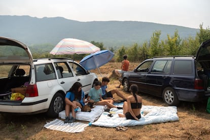 Un grupo de jóvenes desalojados que pasó la noche al raso, en un campamento improvisado durante el incendio de Las Médulas este lunes.