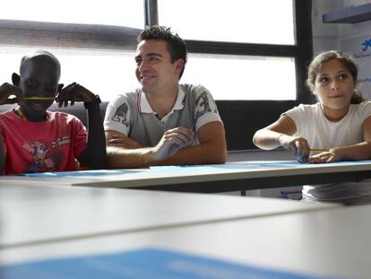 El jugador del Barçca, Xavi Hernández, junto a los niños de la fundación CaixaProinfancia.