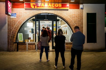 Customers wait in line outside a tobacconists in Pozuelo de Alarcón, Madrid on Friday ahead of planned store closures.