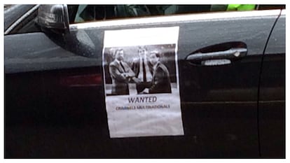 Un cartel de "Se busca" con la foto de Mark MacGann pegado en la puerta de un taxi