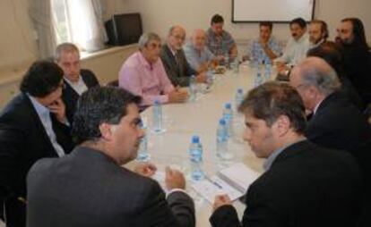 El Jefe de Gabinete argentino, Jorge Capitanich (i- espaldas) y el ministro de Economía, Axel Kicillof (d) participan en una reunión con sindicatos docentes, en Buenos Aires (Argentina). EFE/Archivo