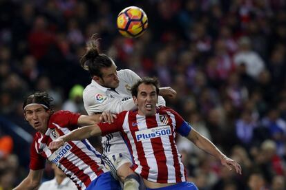 El delantero galés del Real Madrid Gareth Bale (c) lucha el balón con el brasileño Filipe Luis (i) y con Juanfran.