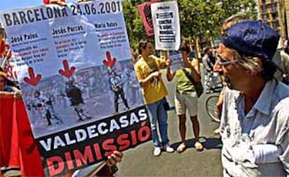 Un manifestante muestra un cartel en el que aparecen supuestos policías infiltrados en la marcha del día 24 contra el Banco Mundial.