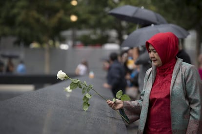 Una mujer deja una flor en el monumento que forma parte del Museo Nacional de la Memoria del 11-S, en la 'Zona Cero' de Manhattan, justo en el lugar donde se encontraban las Torres Gemelas.