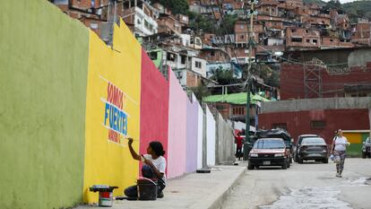 Una joven pinta propaganda chavista en un muro, el 24 de junio en Caracas.