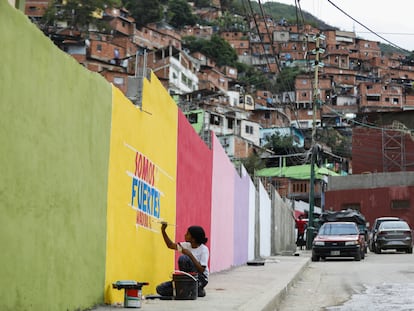 Una joven pinta propaganda chavista en un muro, el 24 de junio en Caracas.