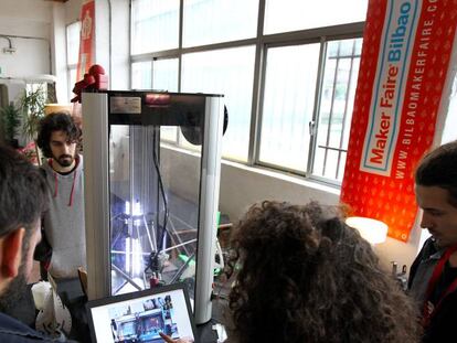 Varios jóvenes interactúan con una impresora 3D fabricada y configurada por ellos en la edición de 2017.