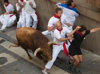 Runners try to move out of the way at the fifth day of the Running of the Bulls in San Fermín.