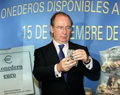 Rato muestra el primer monedero de euros poco antes de la entrada en vigor de la moneda única. (05/12/2001)