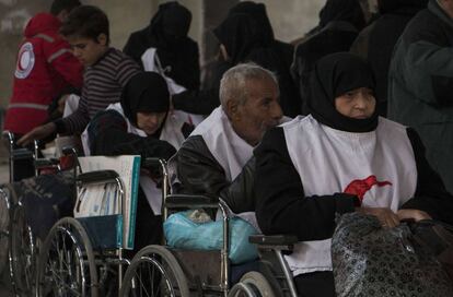 Un grupo de civiles sirios en sillas de rueda aguarda para ser evacuados de una zona rebelde del barrio de Bustan al-Qasr, en Alepo, a través de un corredor humanitario.