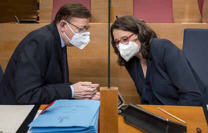 El presidente de la Generalitat, Ximo Puig, conversa con la vicepresidenta, Mónica Oltra, al inicio de la sesión de control en Les Corts de ayer.