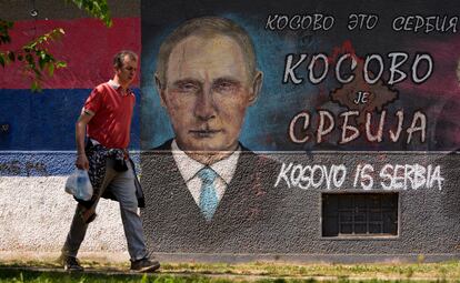 Un hombre pasa junto a un grafiti que representa al presidente ruso, Vladimir Putin, que dice: "Kosovo es Serbia" en Belgrado.