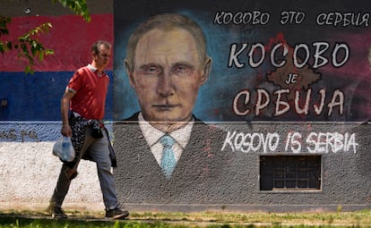 Un hombre pasa junto a un grafiti que representa al presidente ruso, Vladimir Putin, que dice: "Kosovo es Serbia" en Belgrado.