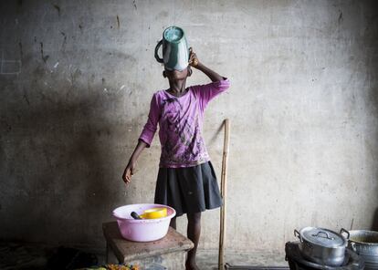 Una niña cocina con cacerolas y boles llenos de moscas. Es habitual que los niños ghaneses tengan que involucrarse en la preparación de las comidas.