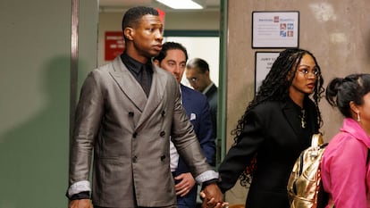 Actors Jonathan Majors and Meagan Good hold hands as they enter the courtroom in New York, New York, on December 18, 2023.