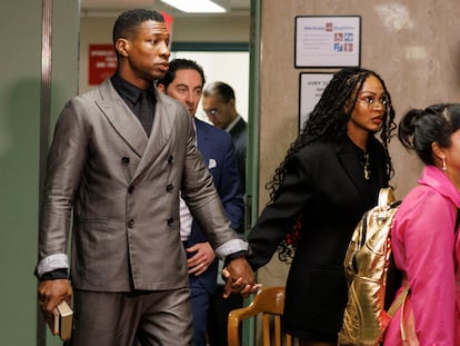 US actors Jonathan Majors (L) and Meagan Good (R) hold hands as they enter the courtroom in New York, December 18, 2023.