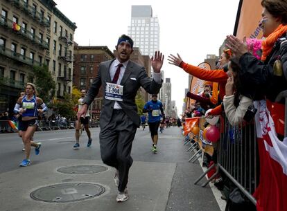 Un hombre con traje y corbata corre por la Primera Avenida de Nueva York, 3 de noviembre de 2013. 