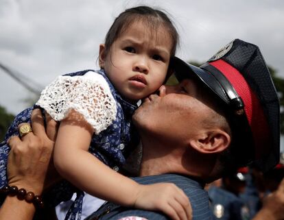 Un policía recién ascendido de rango besa a su hija durante una ceremonia masiva de promoción del cargo, en la sede policial de Taguig (Filipinas), el 27 de marzo.