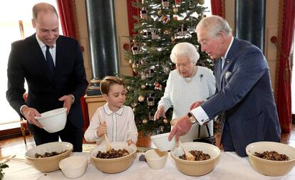 El príncipe Guillermo, el príncipe Jorge, Isabel II y el príncipe Carlos cocinan un pudin navideño en el palacio de Buckingham.