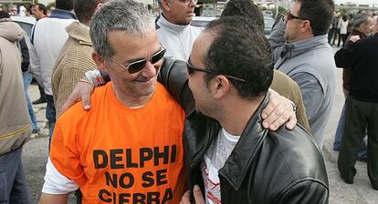 Dos antiguos trabajadores se abrazan en el aniversario del cierre de Delphi en 2008.