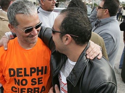 Dos antiguos trabajadores se abrazan en el aniversario del cierre de Delphi en 2008.