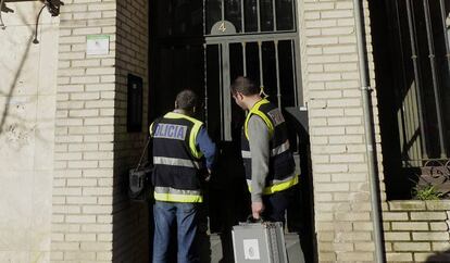 Agentes de la Policía Científica acceden al inmueble cacereño donde se produjo el parricidio.