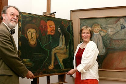 Wulf Herzogenrath y la restauradora Barbara Wiemer sostienen <i>Joven y tres cabezas de hombres,</i> de Munch.