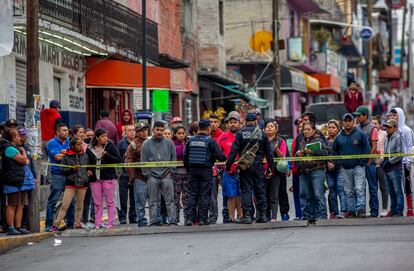 En una fotografía de septiembre de 2019, la policía municipal de Naucalpan (Estado de México) evita que vecinos se acerquen al cuerpo de un joven asesinado.