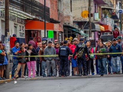 En una fotografía de septiembre de 2019, la policía municipal de Naucalpan (Estado de México) evita que vecinos se acerquen al cuerpo de un joven asesinado.