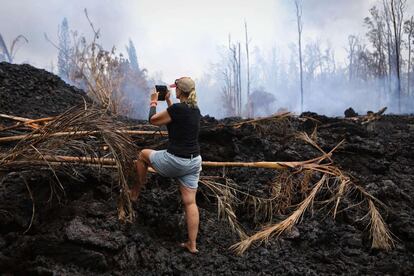 Una vecina de Leilani Estates hace una fotografía de la lava acumulada cerca de su casa, el 7 de mayo de 2018 en Pahoa, Hawái. Tras las evacuaciones a los residentes de Leilani Estates se les ha permitido regresar durante el día para inspeccionar sus propiedad y retirar algunas de sus pertenencias. 