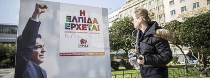 Una joven observa un cartel electoral del l&iacute;der de Syiza, Alexis Tsipras, en el centro de Atenas (Grecia) el viernes 23 de enero de 2015. 