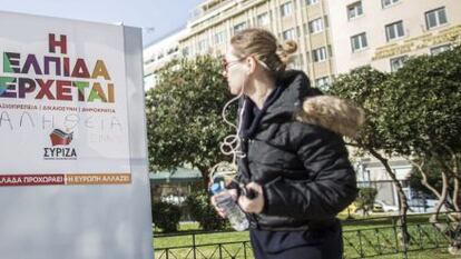 Una joven observa un cartel electoral del l&iacute;der de Syiza, Alexis Tsipras, en el centro de Atenas (Grecia) el viernes 23 de enero de 2015. 