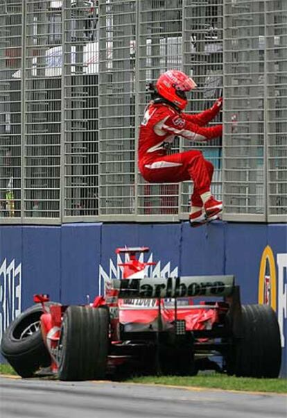 Michael Schumacher se sube a la valla tras estrellar su Ferrari.