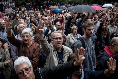 Una multitud levanta los cuatro dedos de una mano en referencia a la bandera catalana mientras esperan a votar en la Escola Industrial de Barcelona.