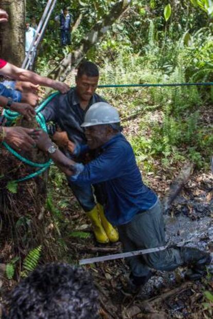 El actor estadounidense Danny Glover muestra su mano manchada de restos de petróleo durante su visita al área donde operó Chevron-Texaco, en la zona de Aguarico 4, en la provincia de Sucumbíos (Ecuador).