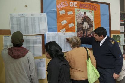 Un grupo de votantes revisa las listas en un colegio electoral en Argentina, el domingo 9 de agosto de 2015.