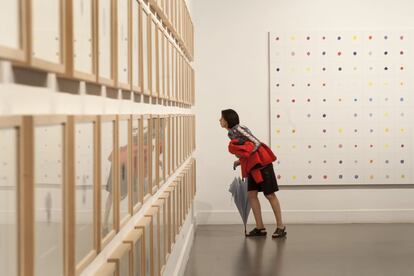 Una visitante observa, en la sala Amós Salvador de Logroño, los dibujos de las flores elaboradas por Carlos Rosales que forman parte de la obra '100 pensamientos necesarios'. Al fondo, 'Viola tricolor', un acrílico de 200x200 centímetros, que forma parte de la misma obra.