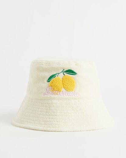 Textura toalla y dos limones bordados: un sombrero de playa para un verano eternamente joven. De H&M.