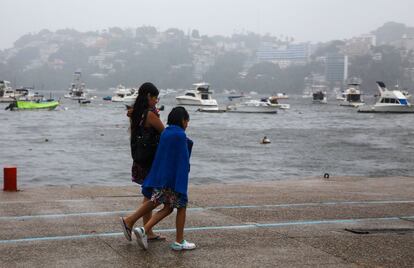 Las fuertes ráfagas de viento también han ocasionado olas de hasta seis metros de altura en diferentes puntos del Pacífico mexicano. En la imagen, una mujer camina junto a sus dos hijos sobre un malecón en Acapulco, momentos antes de la llegada de la tormenta tropical 'Max'. 