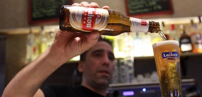 Un empleado de un bar sirve una cerveza.