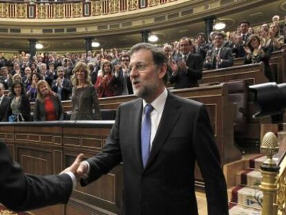 José Luis Rodríguez Zapatero (l) congratulates Rajoy on his election as prime minister.