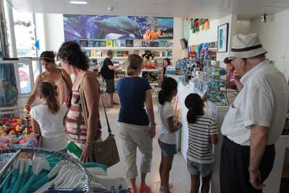 Varias personas mirando los productos que se ofertan en la tienda del Aquarium.